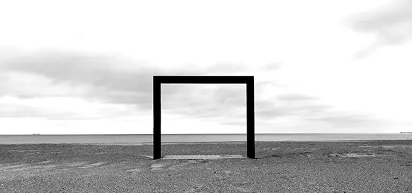 Black metal frame on beach sand