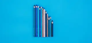 Pencils of different sizes over a blue background