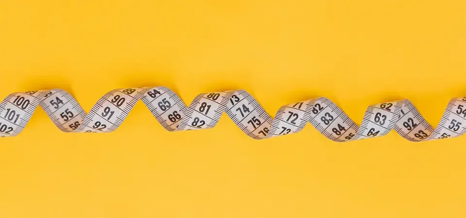 White measuring tape on a yellow background